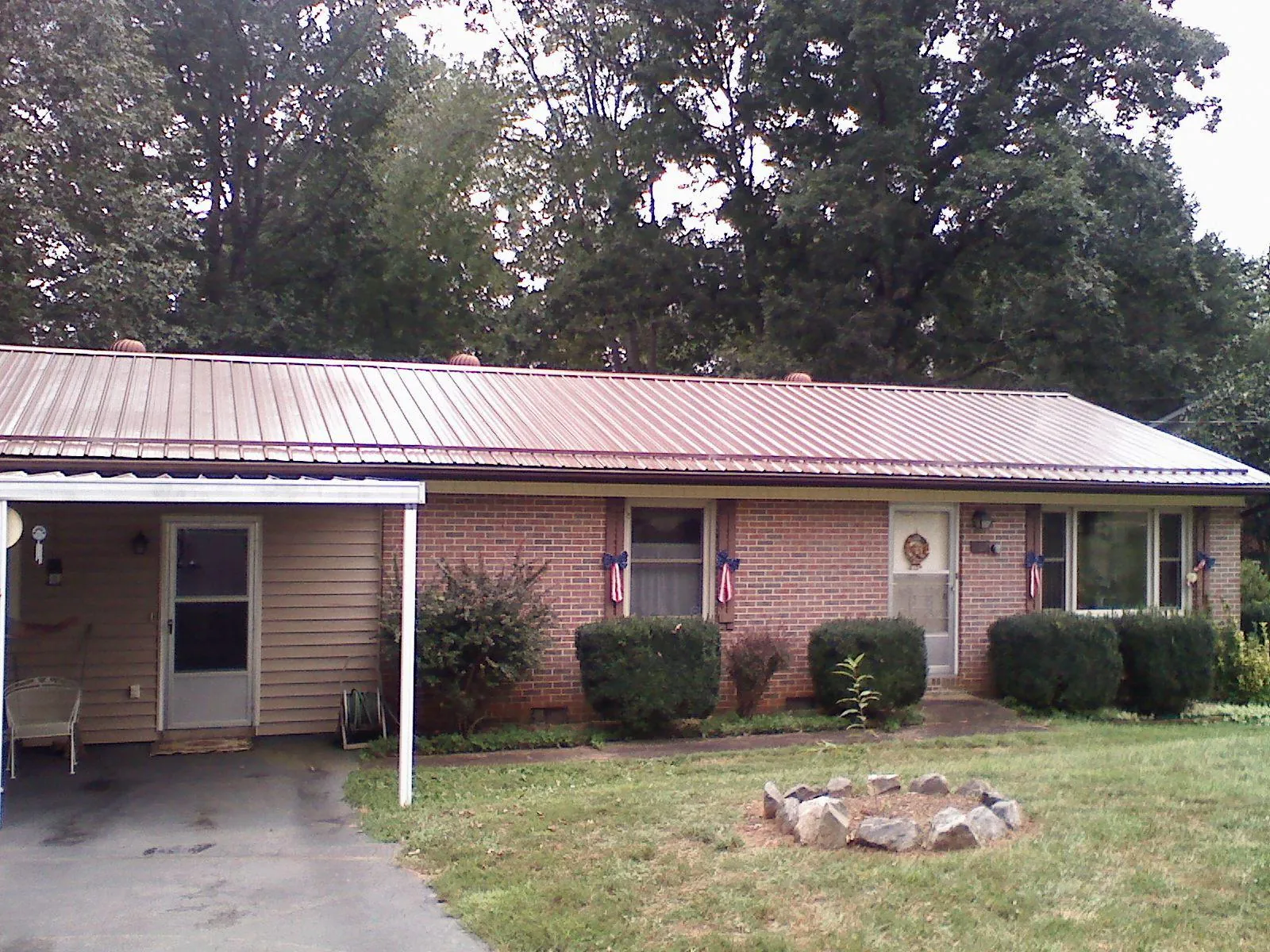 Bronze metal roof and carport on a brick ranch home — Roof Repair work by our crew in Chelsea
